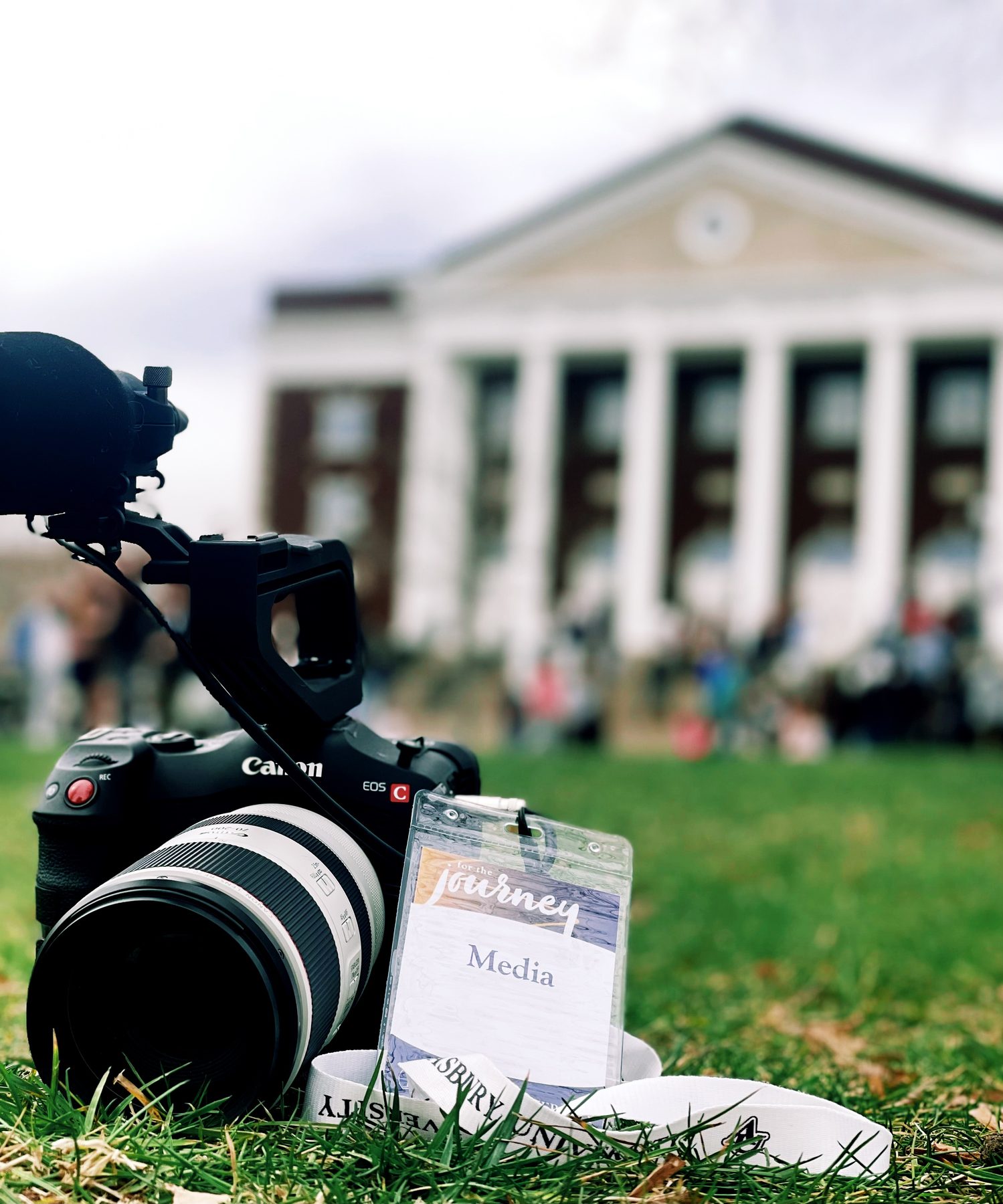 A Canon cinema camera on the lawn with Hughes Auditorium blurred in the background