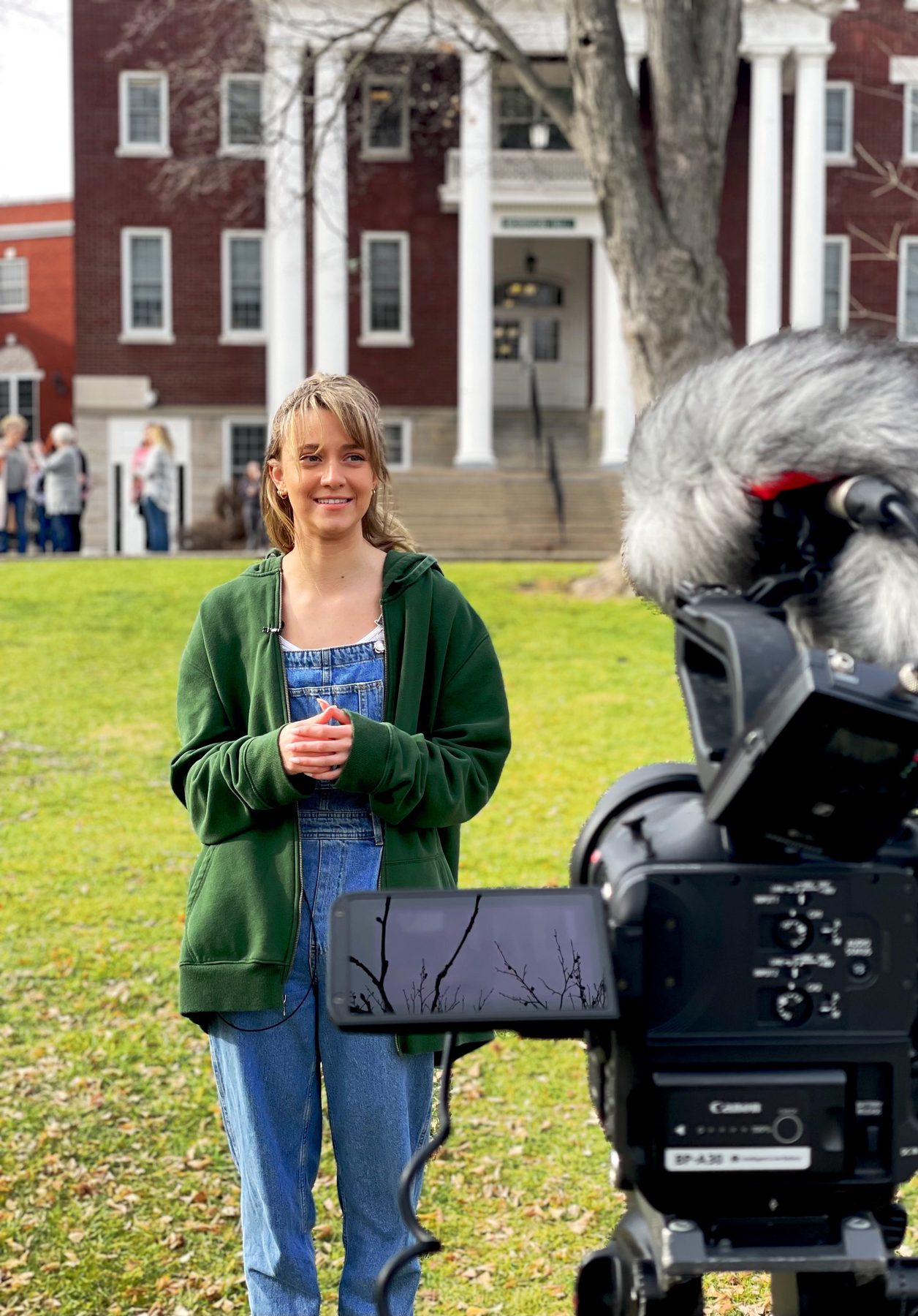 Asbury student Madison Anderson standing on the lawn in front of a documentary camera