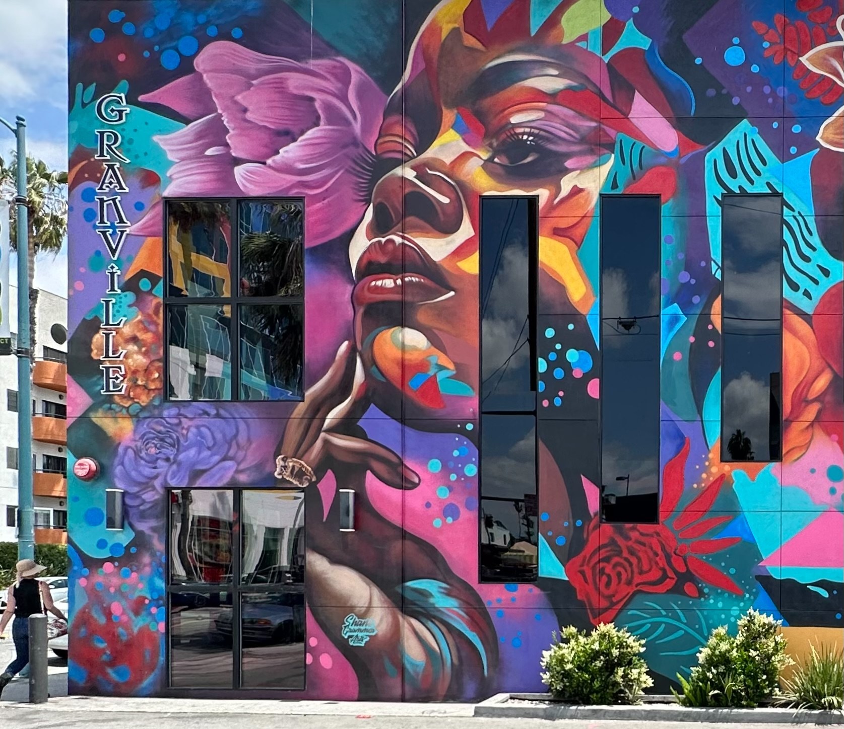 Close-up of the Granville mural showing a painted face beside the vertical Granville sign